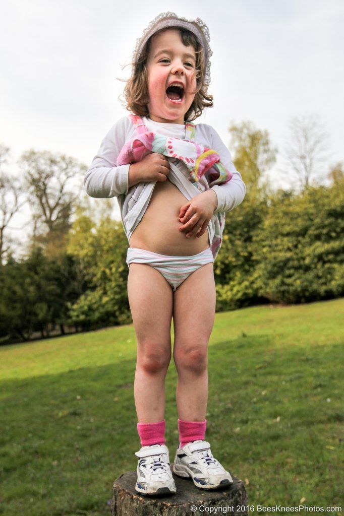 a young girl having a fun time during an outdoor family photoshoot