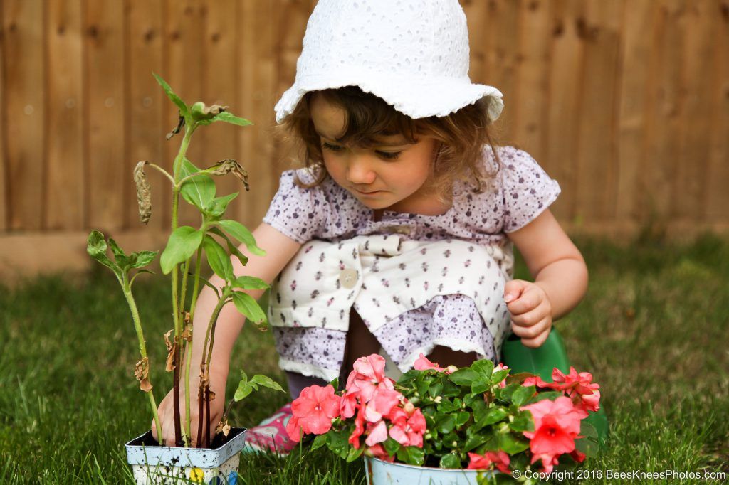 a young girl planting some flowers in the garden