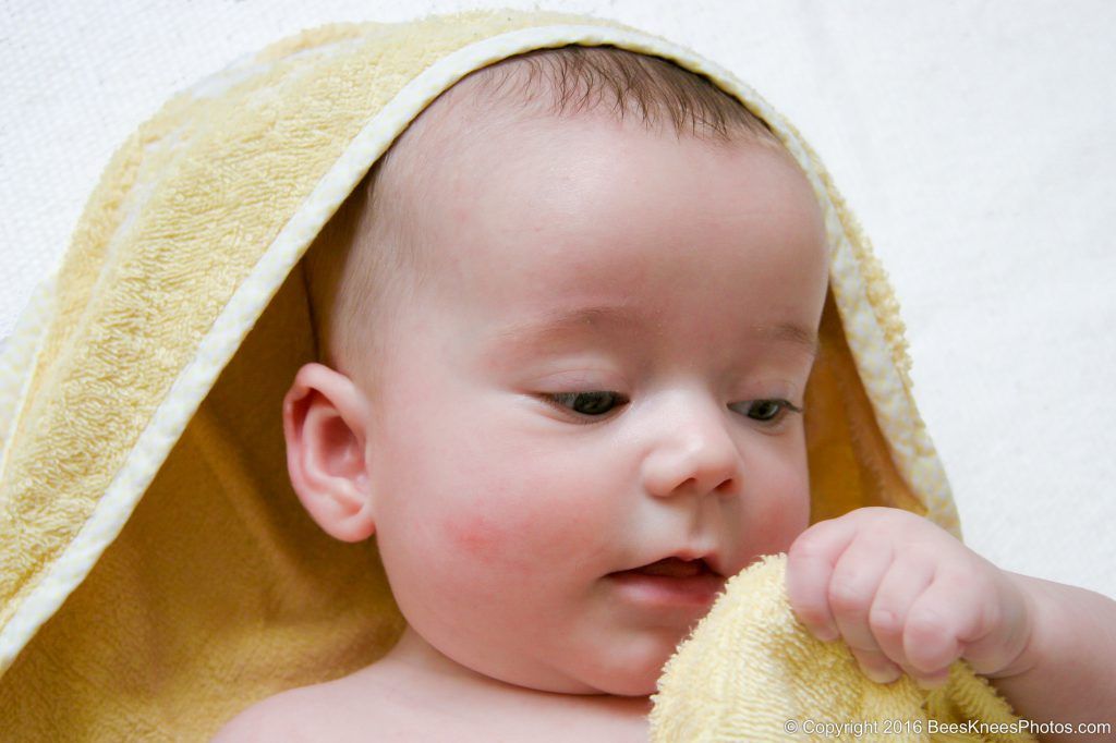 baby playing with a yellow towel