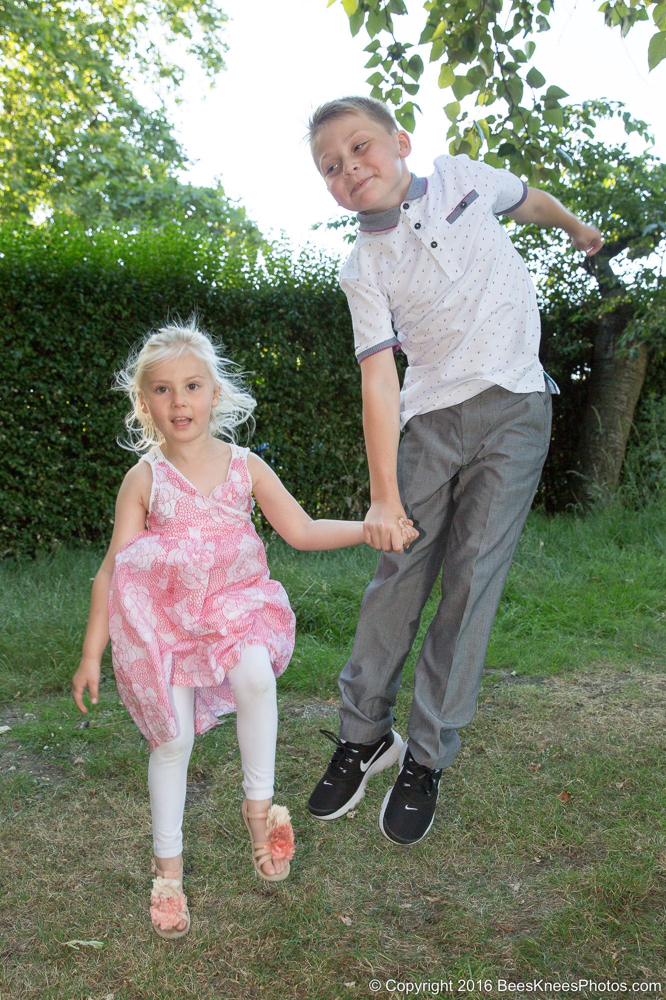 brother and sister jumping around during a photoshoot