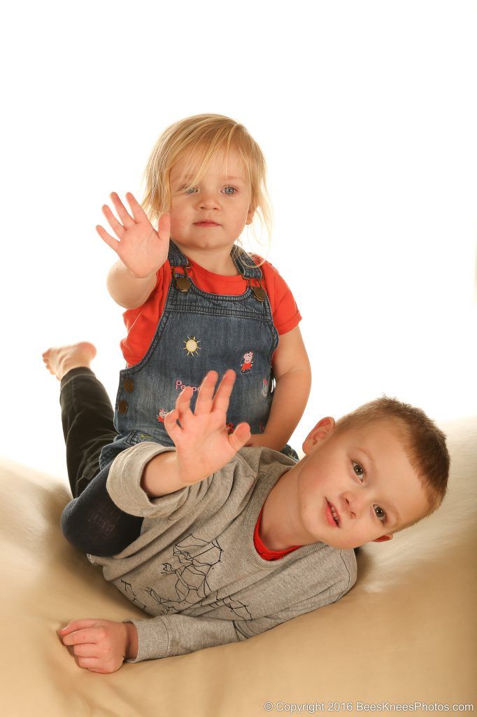 brother and sister waving in the studio