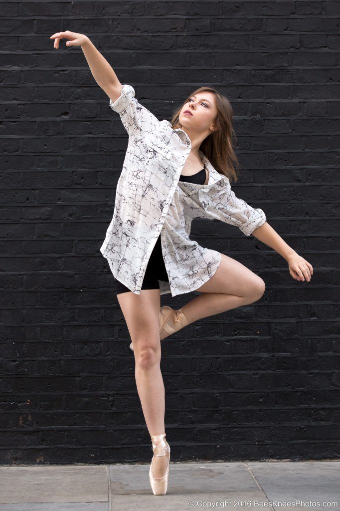 dancer in front of a black brick wall