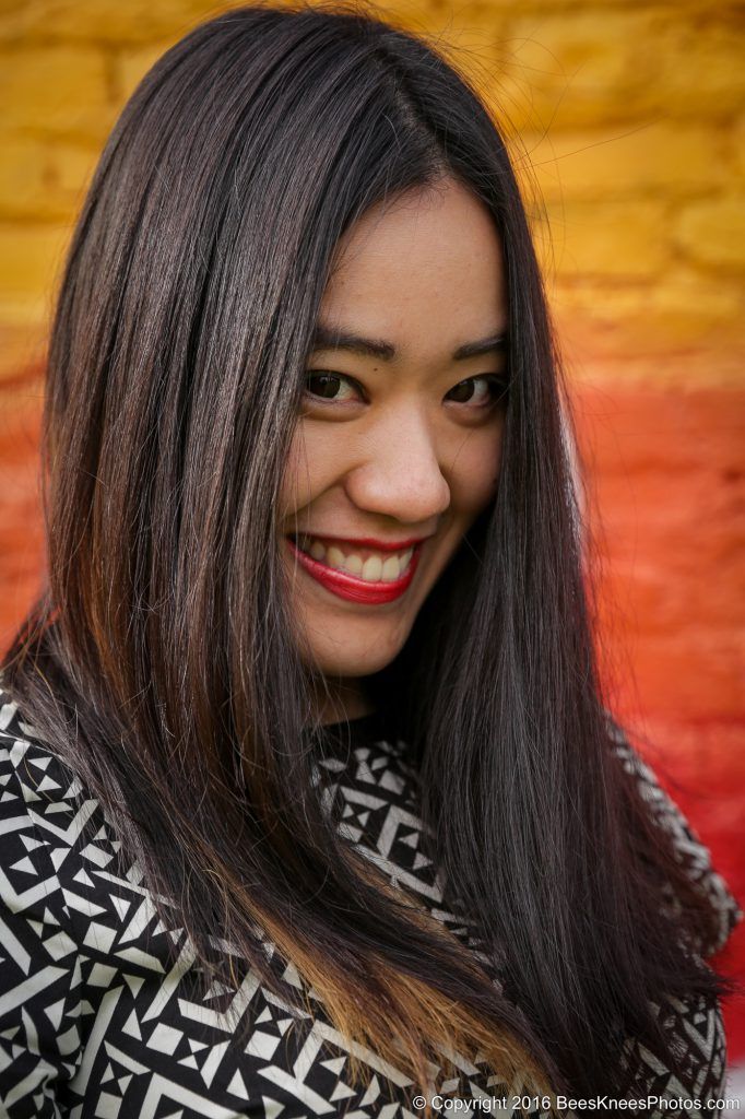 fun female portrait in front of an orange wall