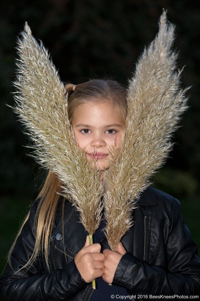 girl holding bushy grass