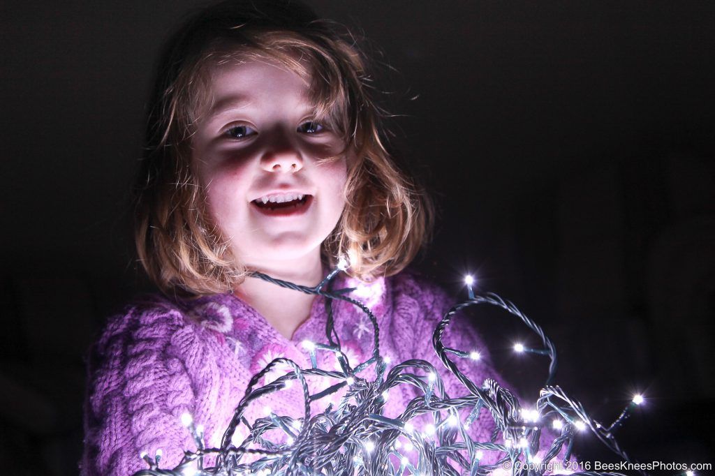 girl holding some christmas fairy lights