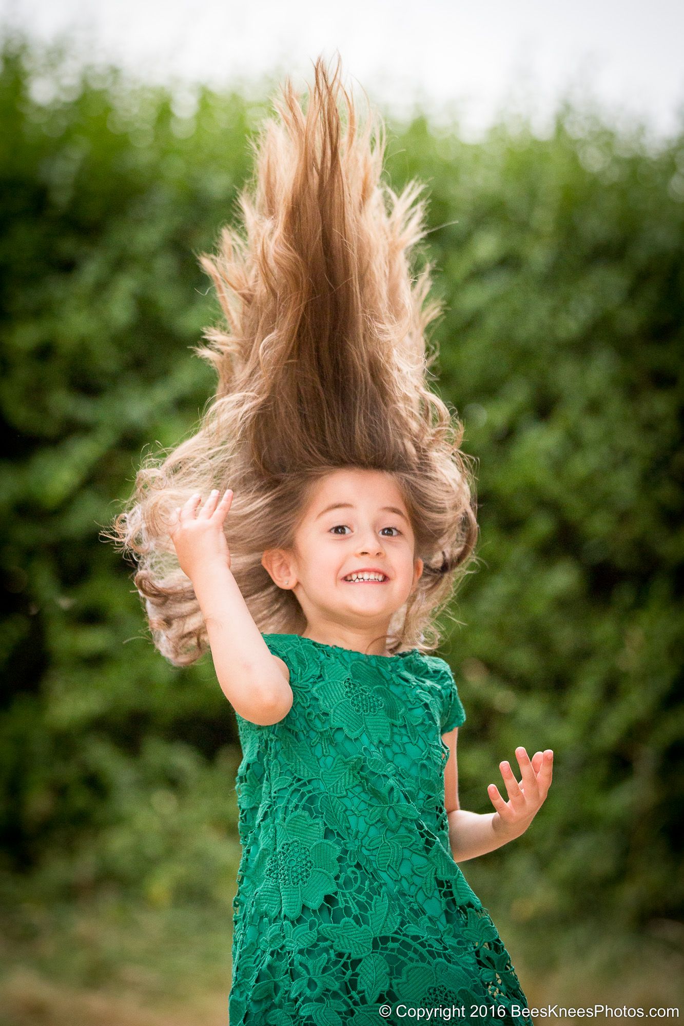 girl in a green dress flinging her hair