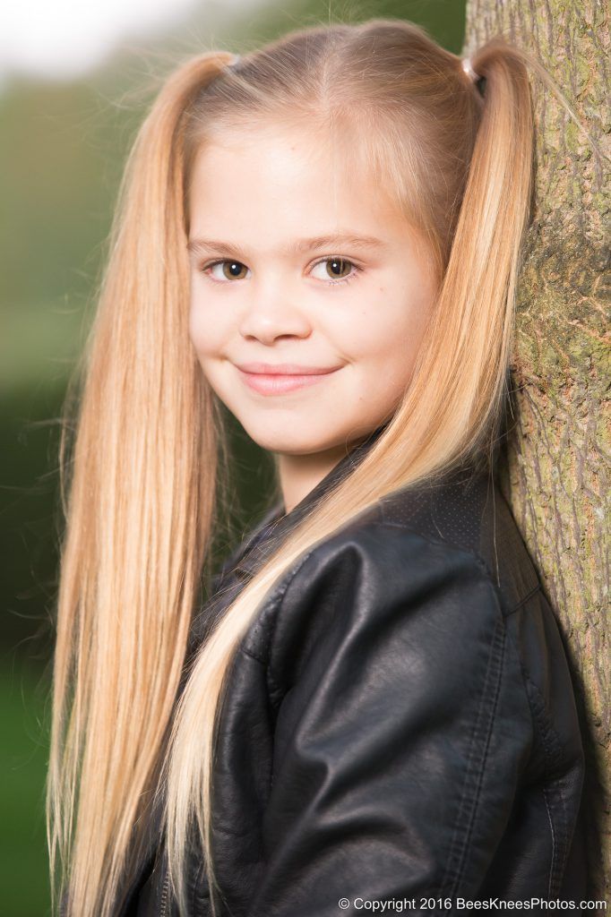 girl leaning against a tree