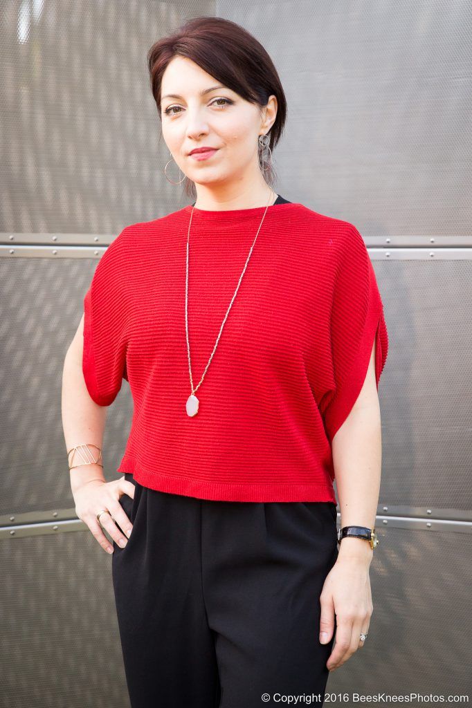 woman in red wearing a long gold necklace