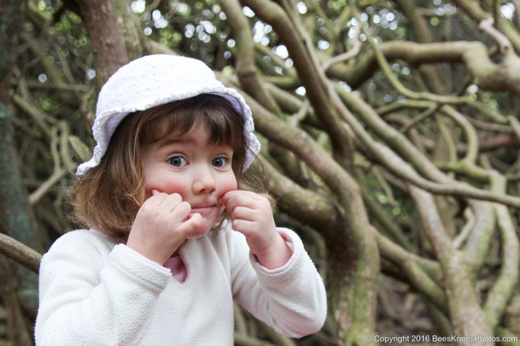 young girl having fun and making faces at an outdoor family photoshoot