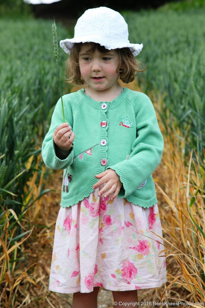 young girl picking a piece of corn