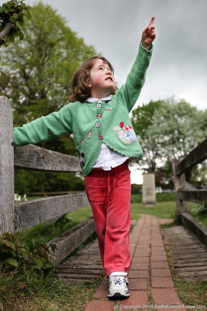 young girl pointing at the sky on an outdoor family photoshoot